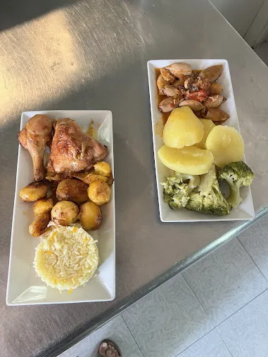 Frango assado com batata e travessa de acompanhamentos